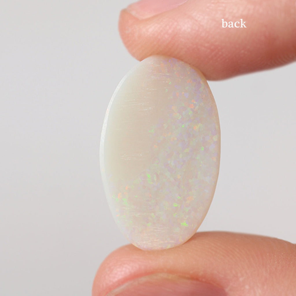 Light opal from Coober Pedy held in hand to show scale