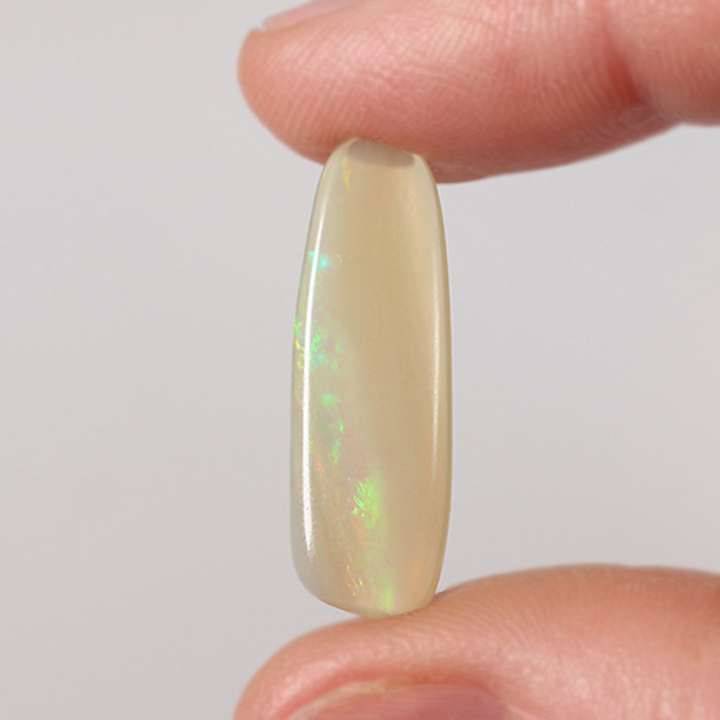 5.8ct dark crystal opal held in hand for scale reference