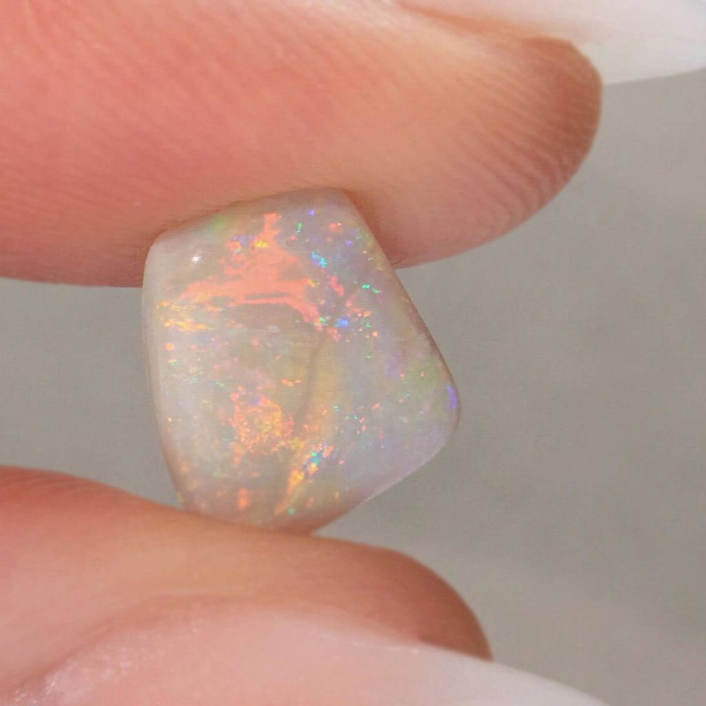 1.3ct lively orange-green light opal cabochon with foil flash pattern