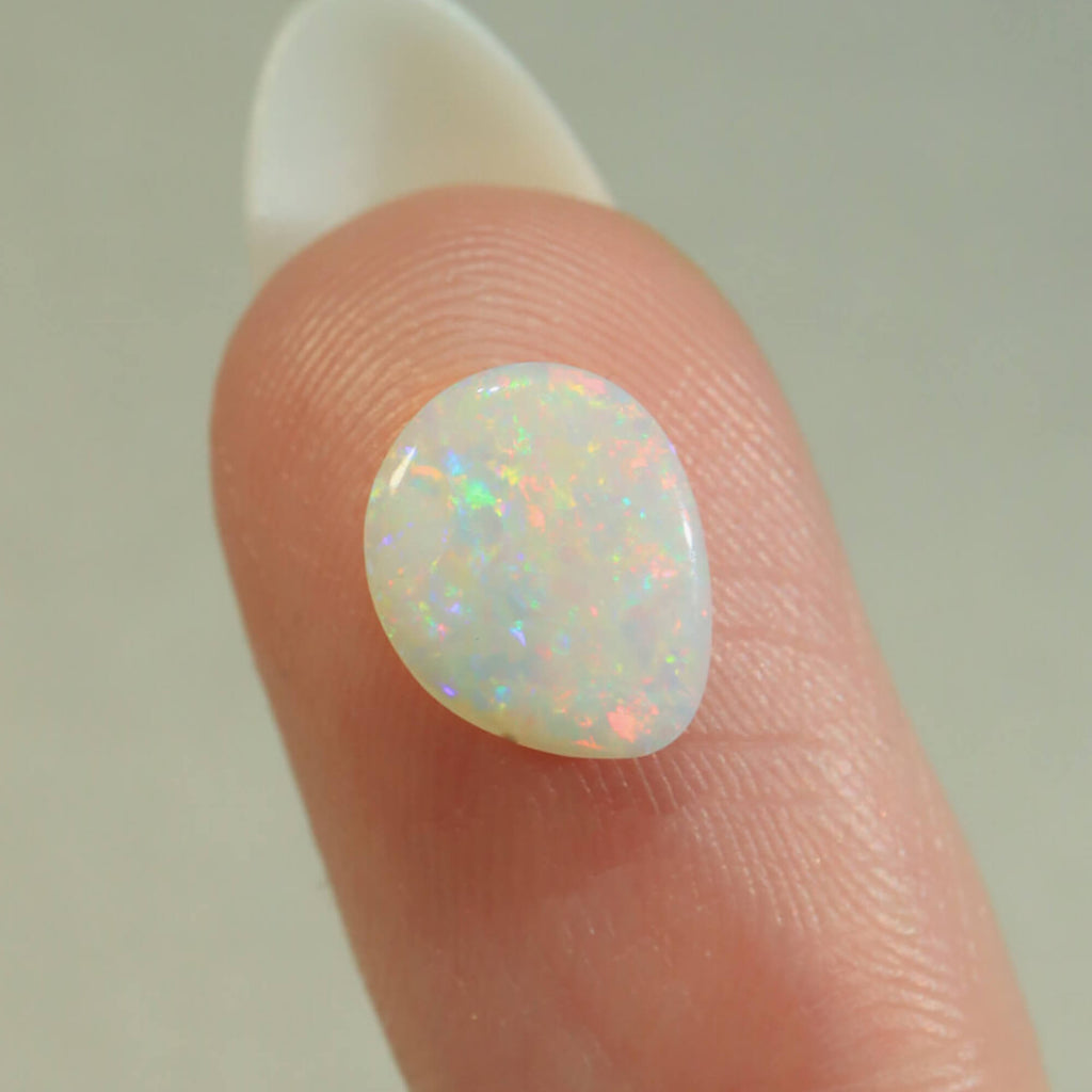 Side view of orange-purple light opal cabochon