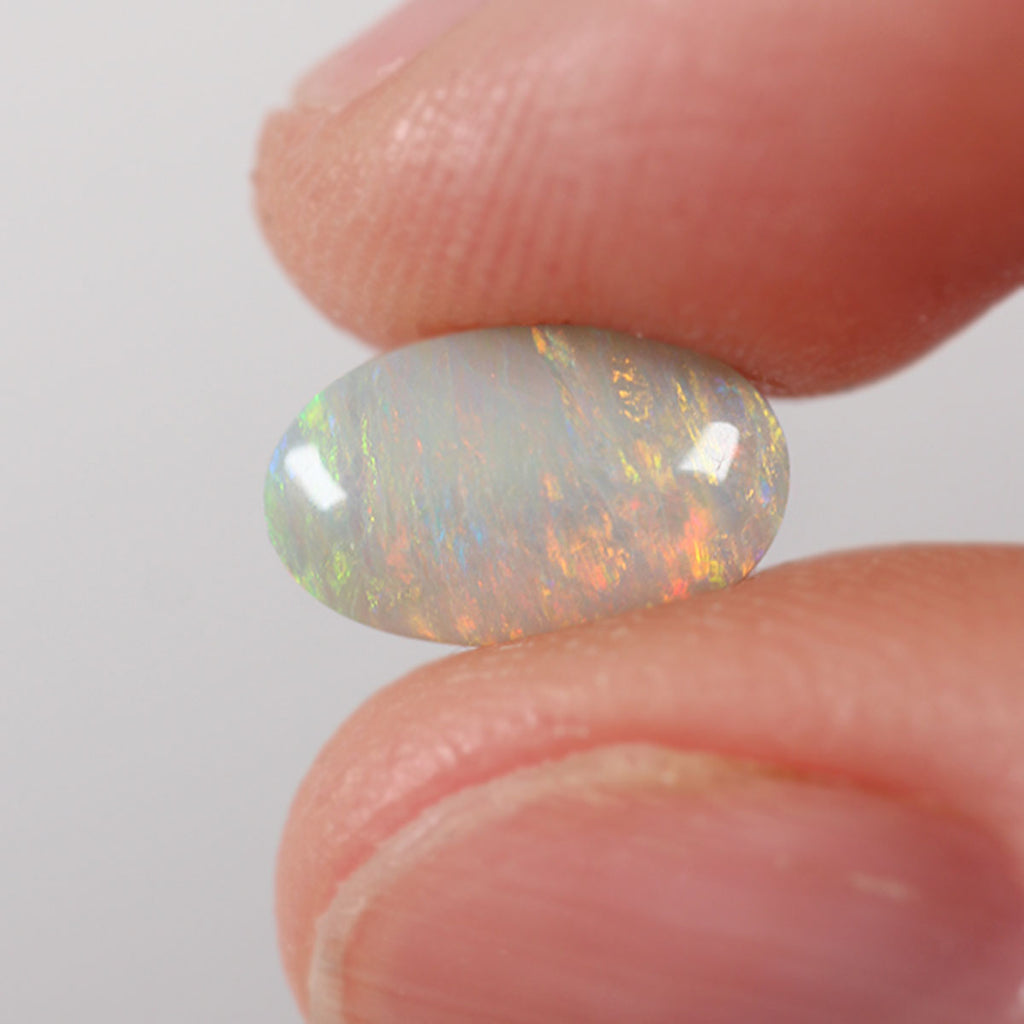 1.35ct dark opal held in hand for scale reference