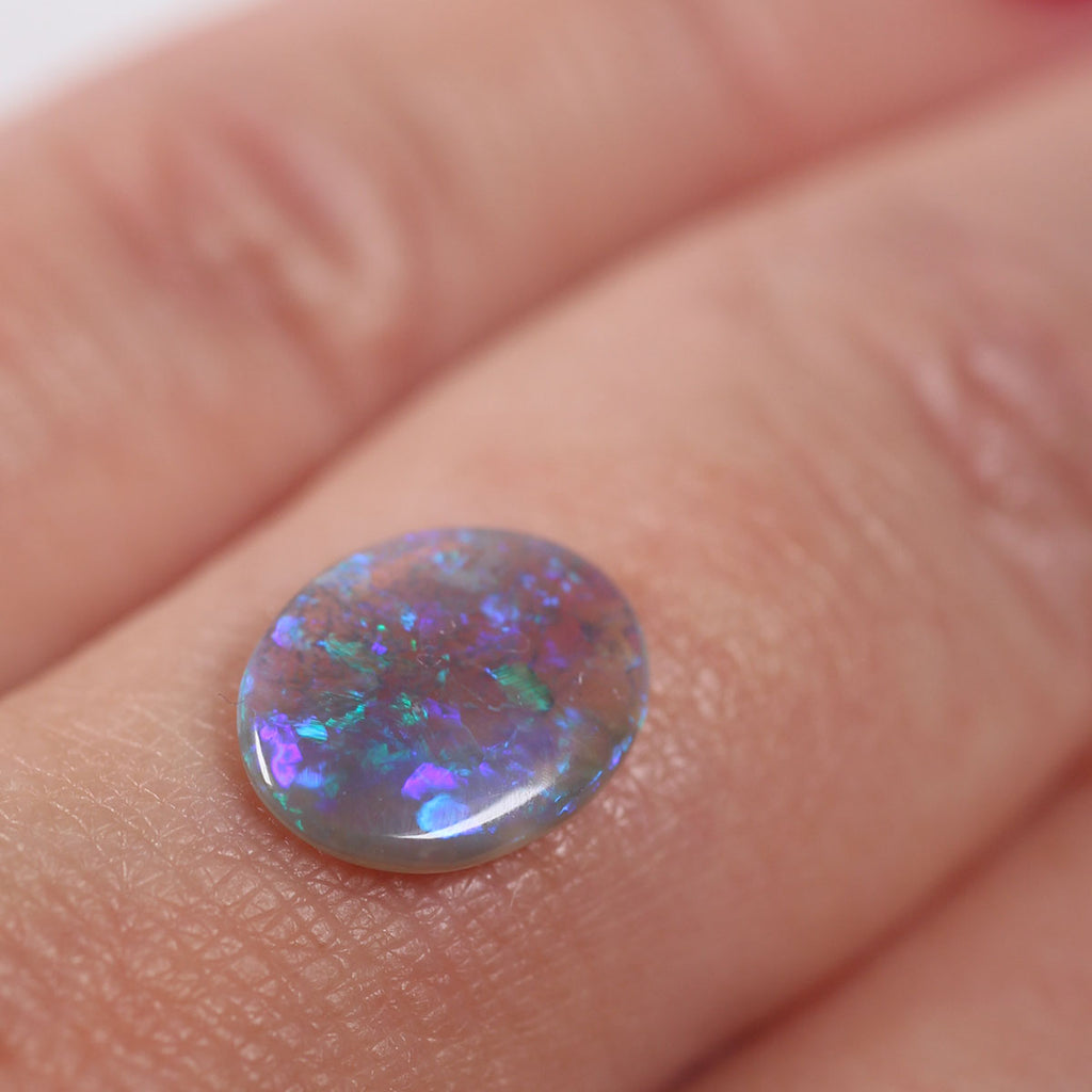 Side view of purple-blue dark crystal opal cabochon