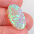 Dark crystal opal from Lightning Ridge held in hand to show scale