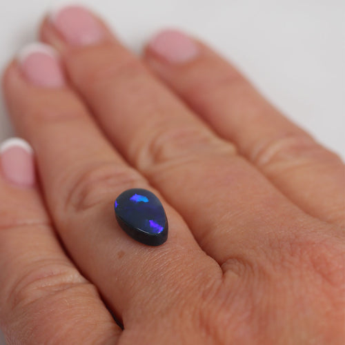 Side view of purple black opal cabochon