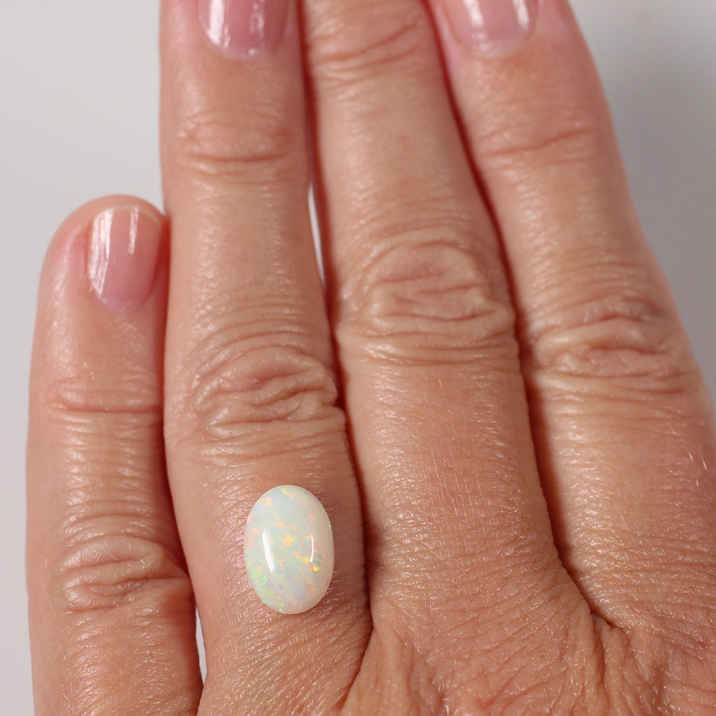 Side view of multicolour light opal cabochon