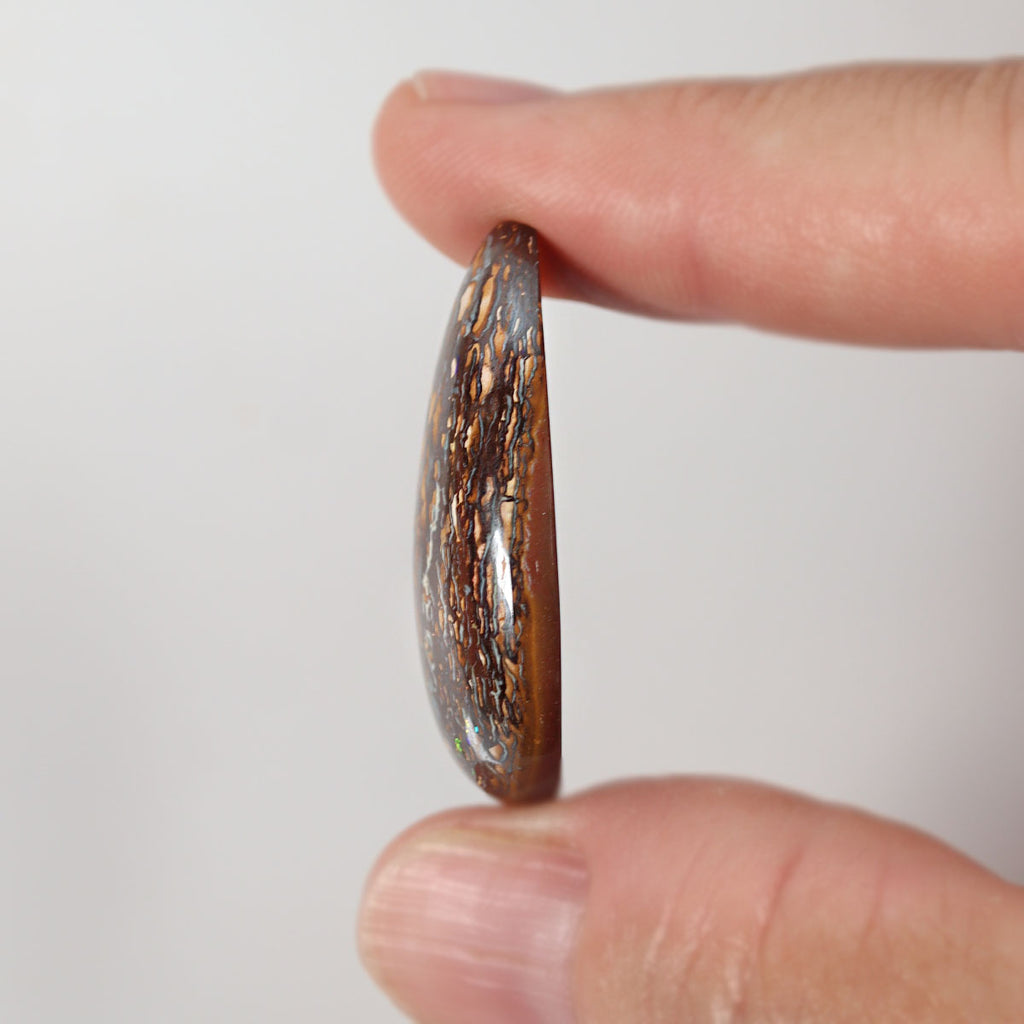 Boulder matrix held between fingers for size reference