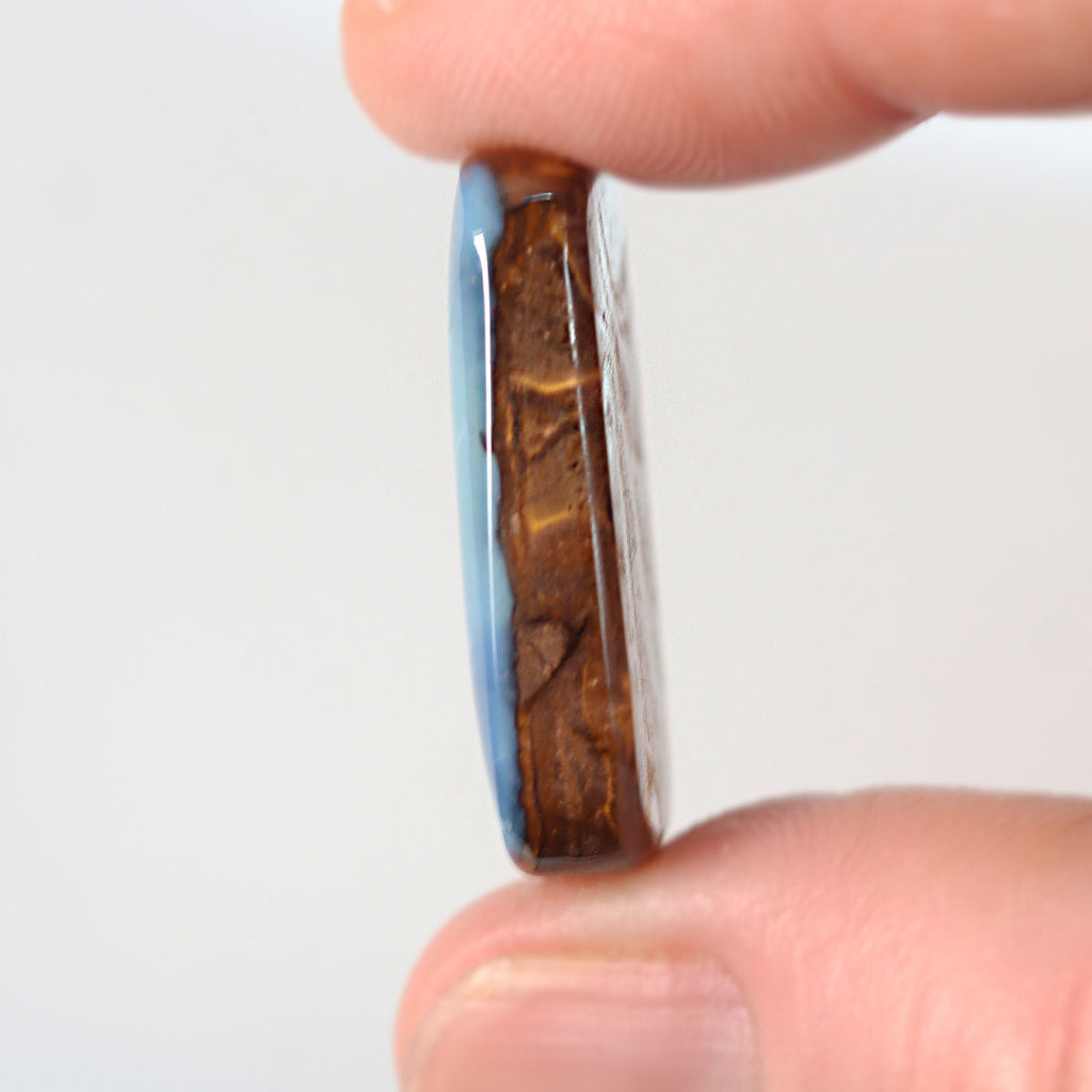 25.83ct boulder opal held in hand for scale reference