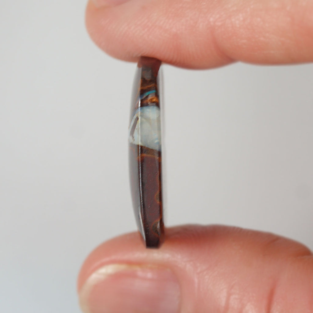 Boulder matrix held between fingers for size reference