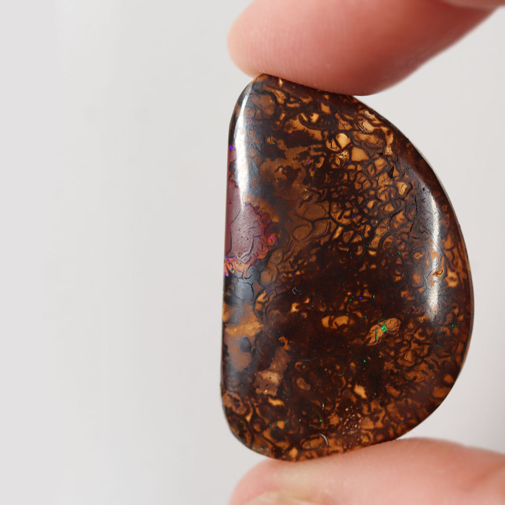 Side view of purple boulder matrix cabochon