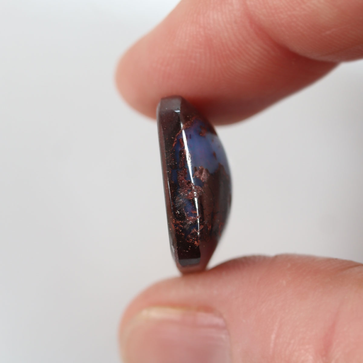 Boulder opal from Yowah held in hand to show scale