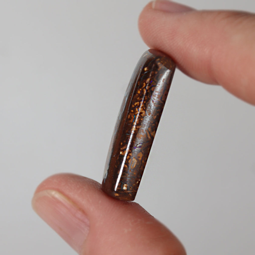Boulder matrix held between fingers for size reference
